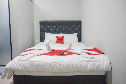 a bedroom with a bed with a red pillow at RedDoorz Plus @ Kalpataru in Rampal