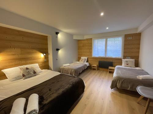 a hotel room with two beds and a window at Appartement spacieux avec Sauna, Parking et Jardin - 115 m2 rez de chaussée, 8 couchages in Font-Romeu-Odeillo-Via