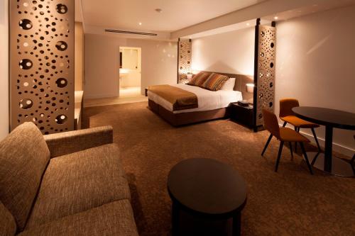 um quarto de hotel com uma cama, um sofá e uma mesa em Bridges Villas Barooga em Barooga