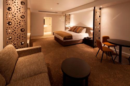 a hotel room with a bed and a couch and a table at Bridges Villas Barooga in Barooga