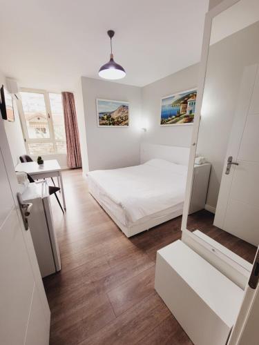 1 dormitorio con cama, mesa y espejo en Nuestra Casa en Tirana