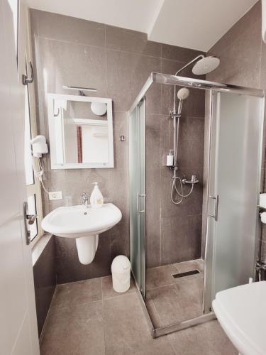 a bathroom with a shower and a sink and a toilet at Nuestra Casa in Tirana