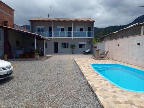 a villa with a swimming pool in front of a house at Casa nova com piscina próxima a praia e menos de 3km do centro de Ubatuba in Ubatuba