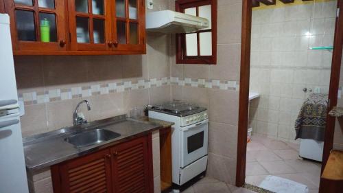 Una pequeña cocina con fregadero y estufa. en Casa duplex EM CONDOMINIO ambiente familiar, en Cabo Frío