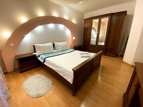 a bedroom with a large bed with an arched ceiling at Видові апартаменти з джакузі в самому центрі in Dnipro