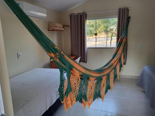 a hammock in a bedroom with a window at Fazendinha Jalapão in Ponte Alta do Norte