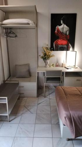 a bedroom with a desk and a bed and a painting at Rainbow Sweet Rooms in Valmontone
