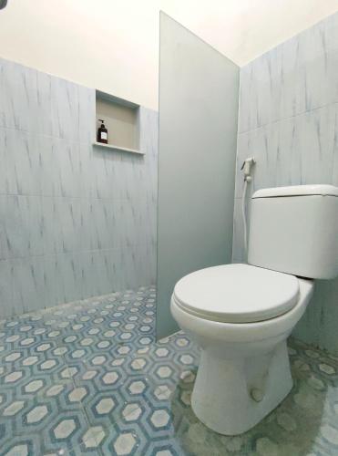 a bathroom with a white toilet in a room at Surabaya Homey near Juanda Airport Syariah in Sedati