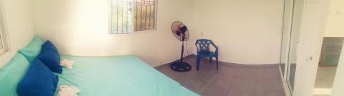 ein Schlafzimmer mit einem Bett und einem Stuhl darin in der Unterkunft La CASA AZUL - Das blaue Haus - The blue house in Las Galeras
