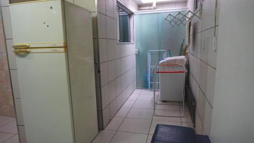 a small kitchen with a refrigerator and a sink at Casa duplex, praia forte. in Cabo Frio