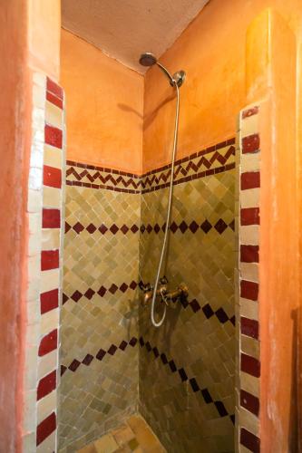 a shower in a bathroom with a tiled wall at Riad Jardin Chrifa in Fès