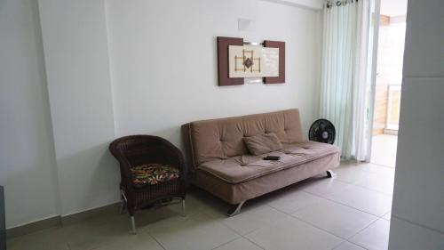 a living room with a couch and a chair at Dubai residência in Cabo Frio
