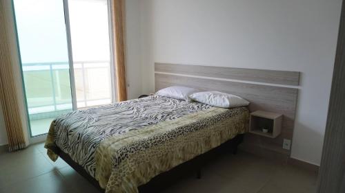 a bed with two pillows on it in a bedroom at Dubai residência in Cabo Frio