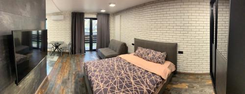 a bedroom with a bed and a brick wall at Уютная квартира возле метро 23 Августа in Kharkiv