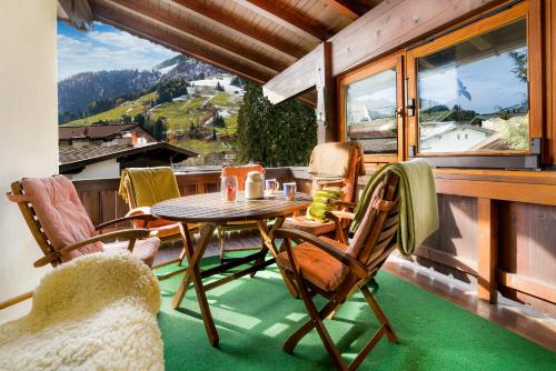 una mesa y sillas en un balcón con vistas en Haus Seinader by Alpine Host Helpers en Kirchberg in Tirol