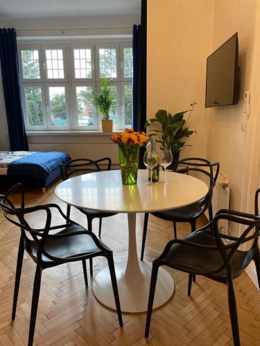a table and chairs in a living room with a table at Willa 1936 , Parking in Toruń