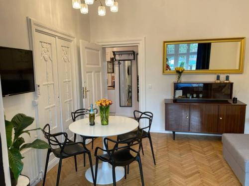 a living room with a table and chairs and a couch at Willa 1936 , Parking in Toruń