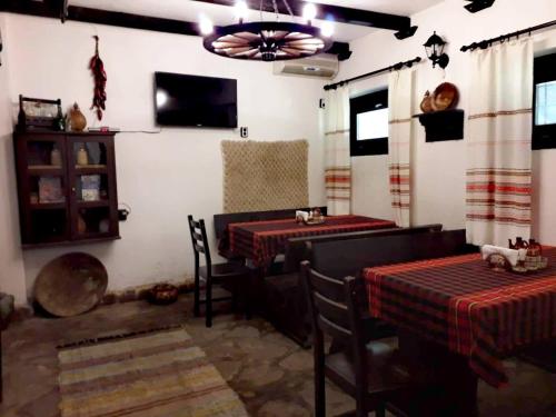 uma sala de jantar com duas mesas e uma televisão em ХАН КОСТИНА - HAN KOSTINA em Ribarica