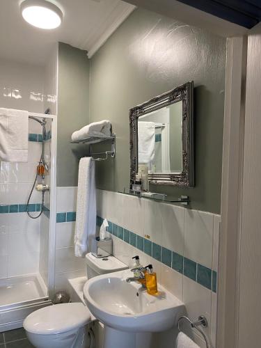 a bathroom with a sink and a toilet and a mirror at The White House Hotel in Newquay