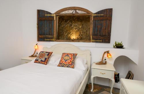 a bedroom with a white bed with two pillows at Aliori art caves in Aegiali