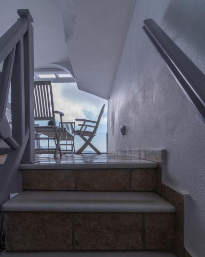 a stairway with two chairs and a bench on it at Nefeli Homes - Adults Only in Imerovigli