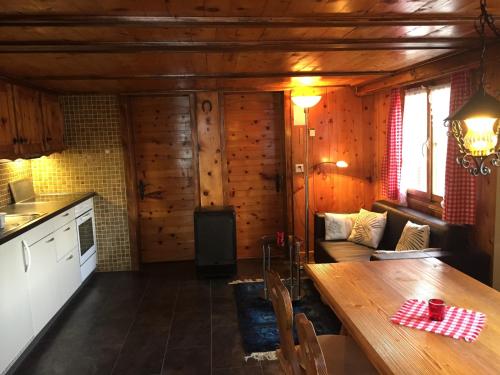 eine Küche und ein Wohnzimmer mit einem Tisch in der Unterkunft Chalet Edith Oberems in Oberems