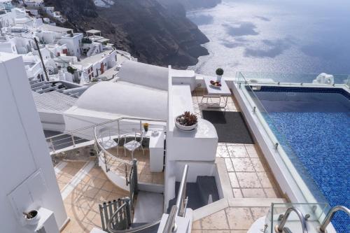 a balcony of a cruise ship with a swimming pool at Nefeli Homes - Adults Only in Imerovigli