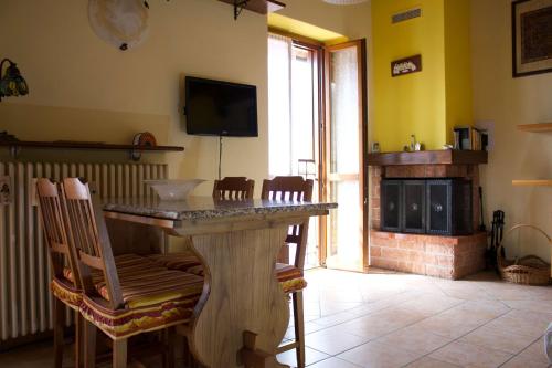 a living room with a table with chairs and a fireplace at La Casa Sul Sasso In town serviced accommodations in Dervio