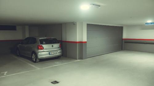 a car parked in a garage with a garage door at JACUZZI RELAX APARTMENT in Subotica