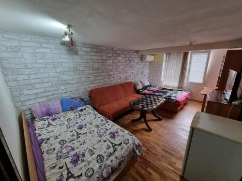 uma sala de estar com uma cama e um sofá em 2 стаен до парка em Razgrad