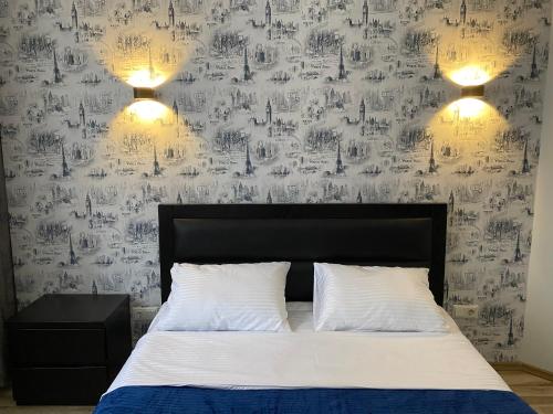 a bedroom with a bed and a wall covered in writing at Cozy Apartment In Ortacahala in Tbilisi City