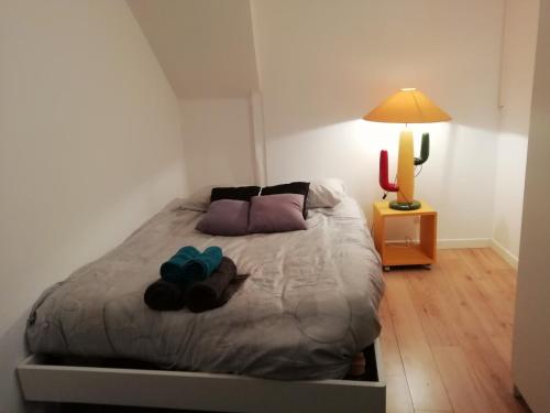 a bedroom with a bed with two pillows and a lamp at L'éden Quercynois in Souillac