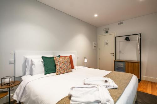 波多的住宿－Porto River Infante，卧室配有一张白色的大床和一张桌子