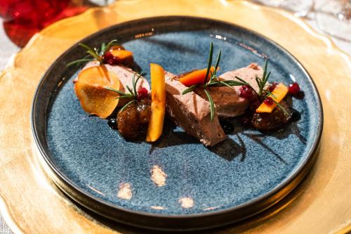 a blue plate with meat and vegetables on a table at Hotel De Kalvaar in Ninove
