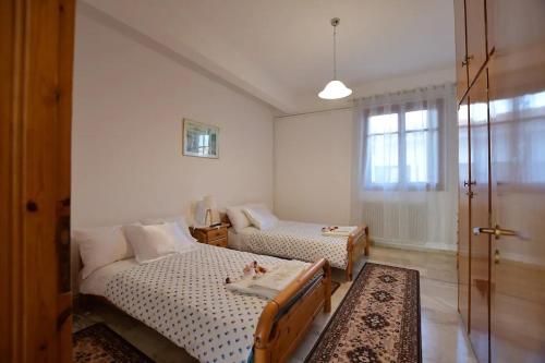 um quarto com 2 camas e uma porta de vidro deslizante em Relaxing experiences near Ancient Olympia em Archea Pissa