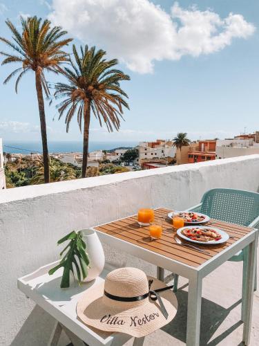 a table with food on a balcony with palm trees at Villa Nestor in Ingenio
