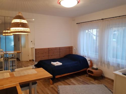 1 dormitorio con cama, mesa y comedor en Kislak a Pilisben - Budapest vonzásában, en Pilisvörösvár