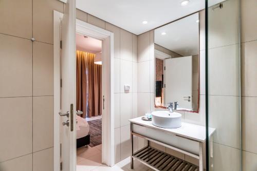 y baño con lavabo y espejo. en Olive Arena Boutique&Business Hotel-By Ran Hotels en Nahariyya