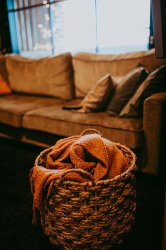 a wicker basket with a couch in a living room at Ylämaja - with a stunning view in Ruka