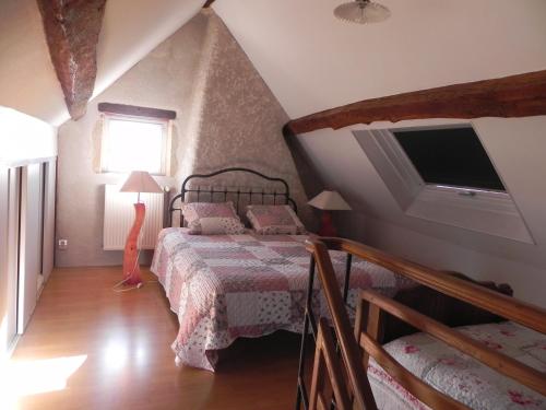 a bedroom with a bed and a television in a attic at Chambre d'hôtes Domaine de la Guinchère in LʼHôpital-le-Mercier