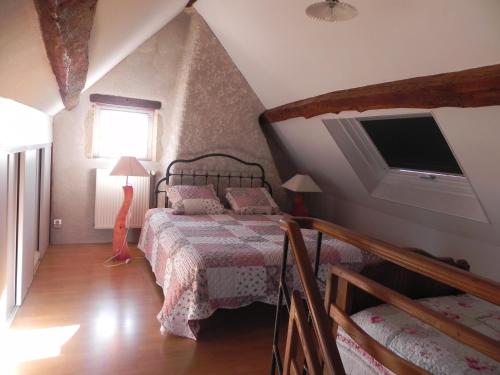 een slaapkamer met een bed en een televisie op zolder bij Chambre d'hôtes Domaine de la Guinchère in LʼHôpital-le-Mercier