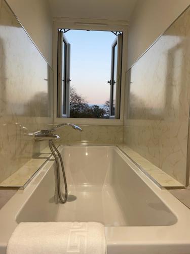 a bath tub with a faucet and a window at Woodhouse Farm Lodge in Spalding