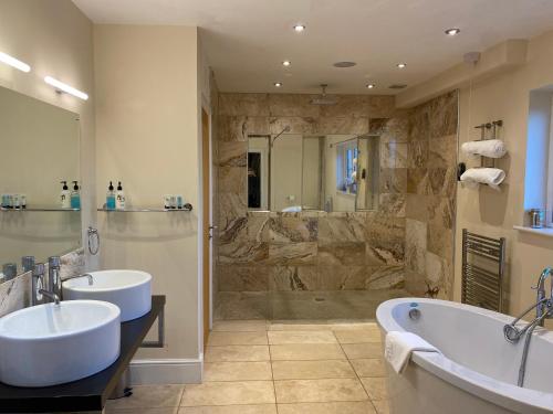 a large bathroom with two sinks and a shower at Woodhouse Farm Lodge in Spalding