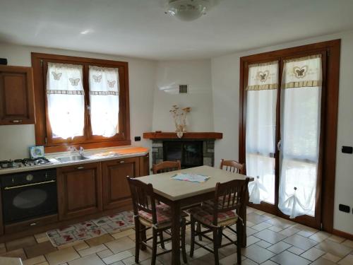a kitchen with a table and a sink and a stove at APPARTAMENTO CORTAIOLO HOUSE in Vione