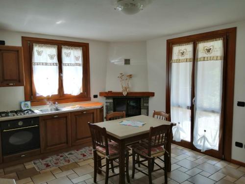 a kitchen with a table and a sink and a stove at APPARTAMENTO CORTAIOLO HOUSE in Vione