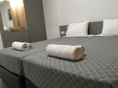 two rolled towels sitting on top of a bed at Elenapa Holiday Apartments in Ayia Napa
