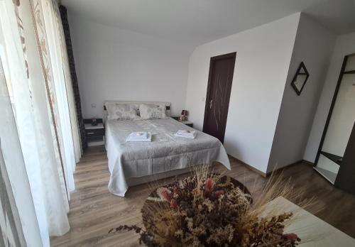 ein Schlafzimmer mit einem Bett in einem Zimmer mit weißen Wänden in der Unterkunft Candy Pensiune&Restaurant in Dumbrava Roşie