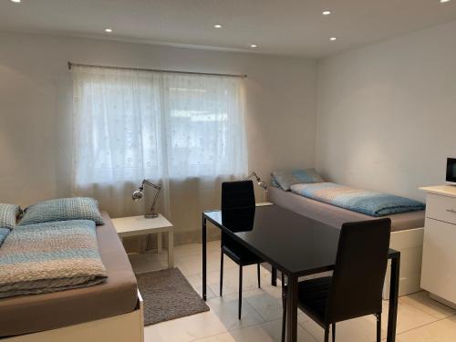 a room with two beds and a table and a desk at City Apartments in Bad Säckingen