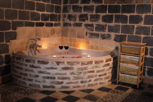 a bath tub with candles and wine glasses in it at B&B 't Zwaluwnest in Heuvelland