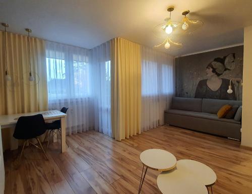 a living room with two tables and a couch at Apartamencik przy starówce in Lądek-Zdrój
